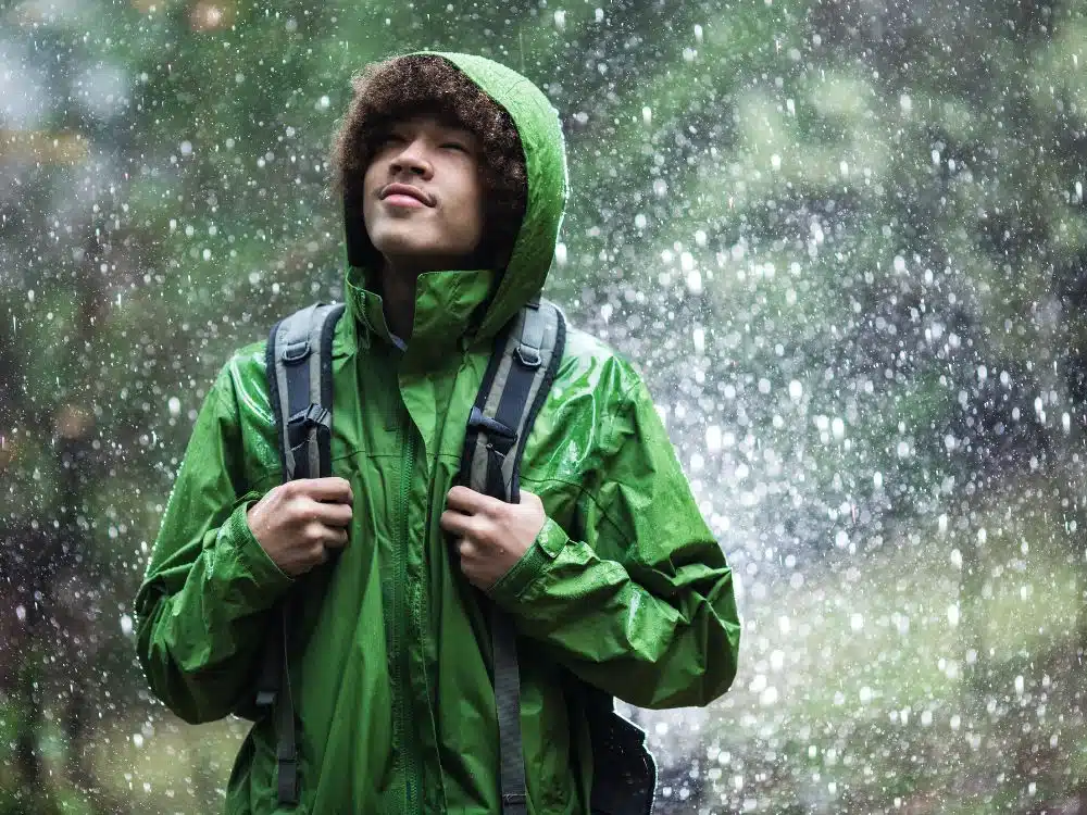 Detalle de tejido y capucha ajustable en casaca impermeable para exteriores